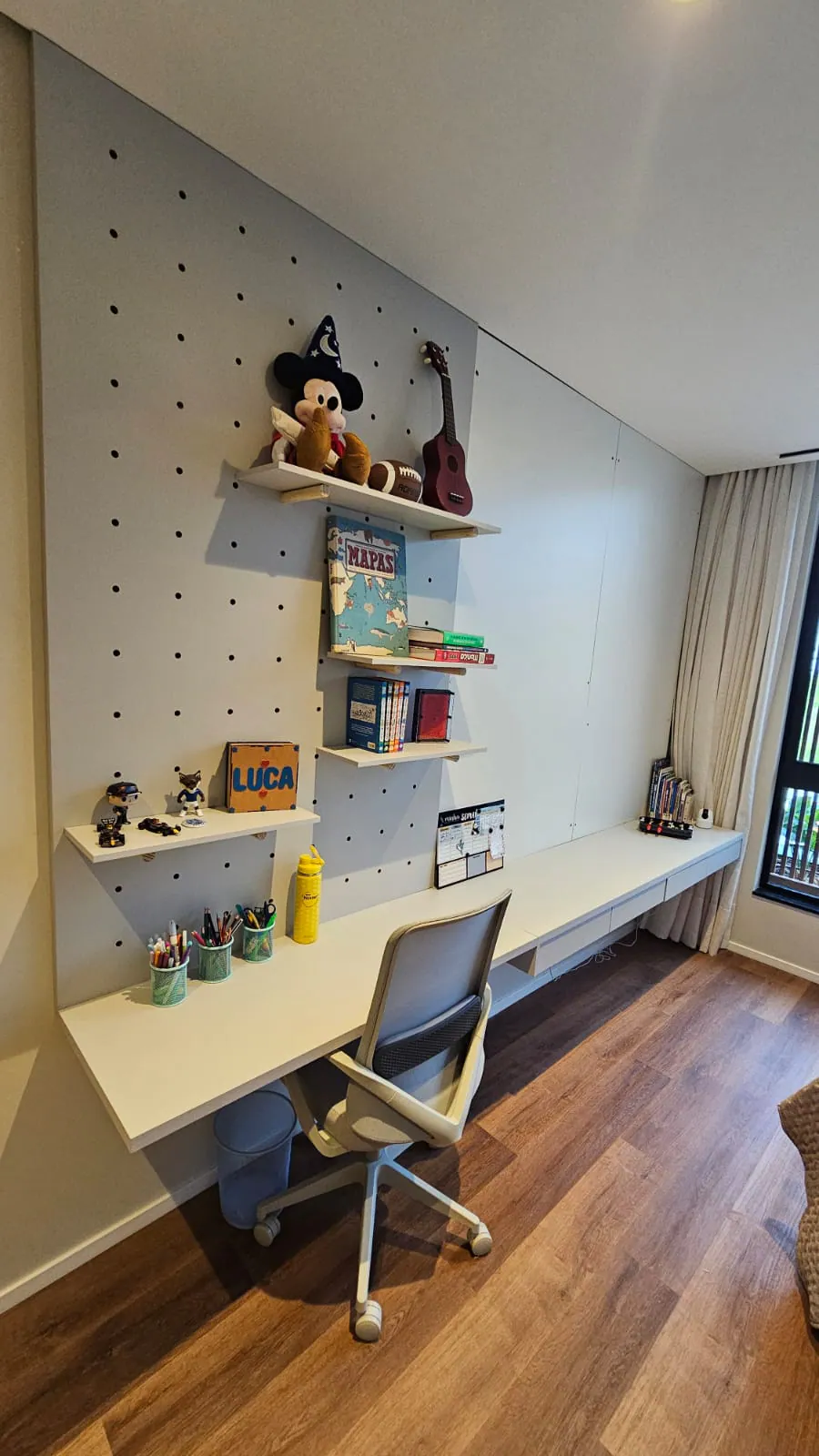 Quarto com escrivaninha, painel perfurado e prateleiras