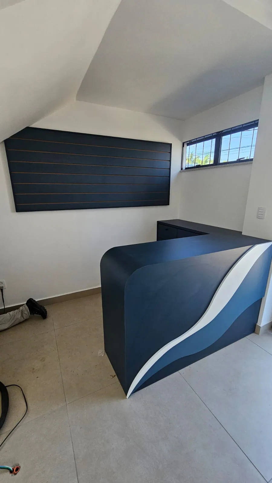 Balcão de recepção curvo azul com faixa branca
